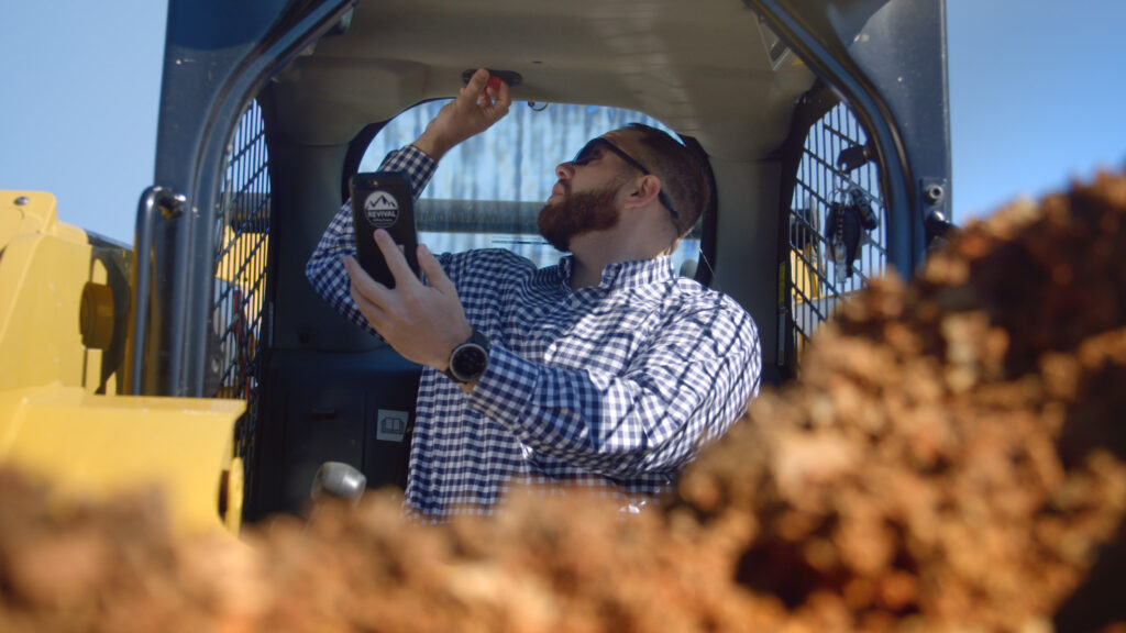 Man Checking Emergency Switch in Skid Steer