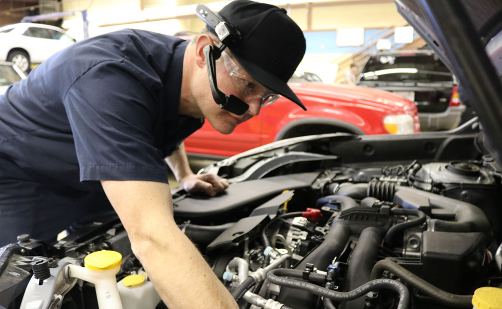 Auto Technician Working on Vehicle Engine